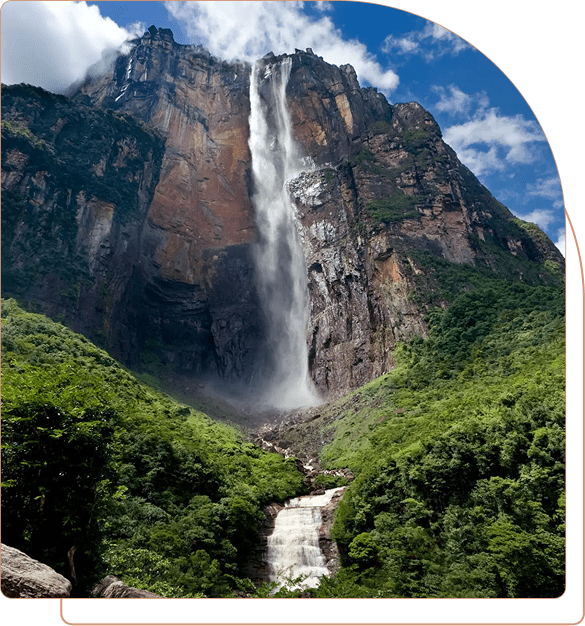 Majestic waterfall cascading down a rocky cliff surrounded by lush greenery.